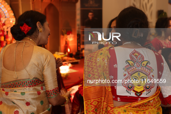 A Bengali Hindu woman wears a saree blouse (choli) with an image of the Goddess Durga during the Durga Puja festival at a pandal (temporary...