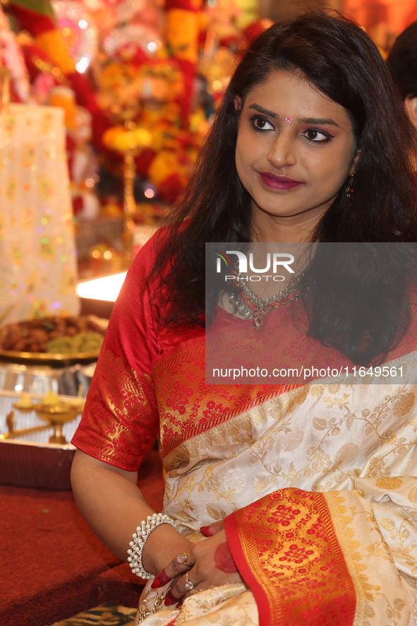 A Bengali Hindu woman dresses in a traditional saree during the Durga Puja festival at a pandal (temporary temple) in Mississauga, Ontario,...