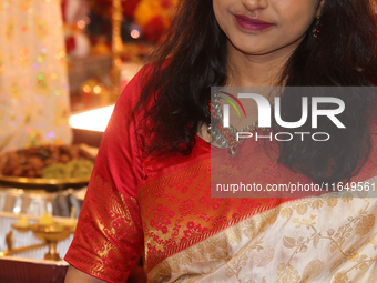 A Bengali Hindu woman dresses in a traditional saree during the Durga Puja festival at a pandal (temporary temple) in Mississauga, Ontario,...