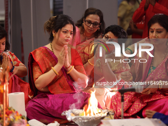 Bengali Hindu women perform prayers during the Durga Puja festival at a pandal (temporary temple) in Mississauga, Ontario, Canada, on Octobe...