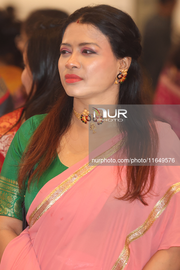 A Bengali Hindu woman listens as prayers are recited during the Durga Puja festival at a pandal (temporary temple) in Mississauga, Ontario,...