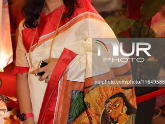 A Bengali Hindu woman wears a saree with the image of the Goddess Durga during the Durga Puja festival at a pandal in Mississauga, Ontario,...