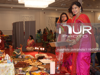 Bengali Hindu women carry trays of offerings during the Durga Puja festival at a pandal (temporary temple) in Mississauga, Ontario, Canada,...