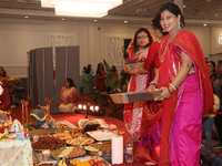 Bengali Hindu women carry trays of offerings during the Durga Puja festival at a pandal (temporary temple) in Mississauga, Ontario, Canada,...