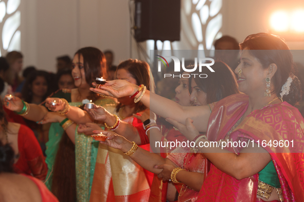 Bengali Hindu women perform prayers during the Durga Puja festival at a pandal (temporary temple) in Mississauga, Ontario, Canada, on Octobe...