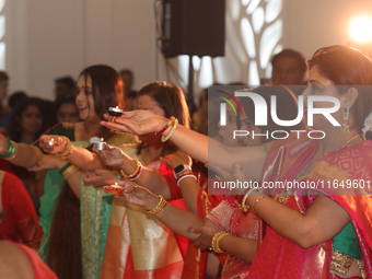 Bengali Hindu women perform prayers during the Durga Puja festival at a pandal (temporary temple) in Mississauga, Ontario, Canada, on Octobe...