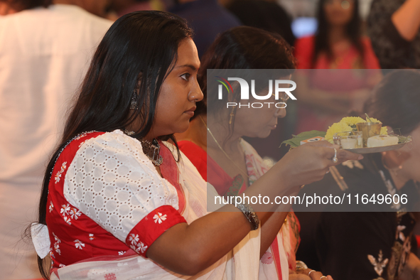 Bengali Hindu women perform prayers during the Durga Puja festival at a pandal (temporary temple) in Mississauga, Ontario, Canada, on Octobe...