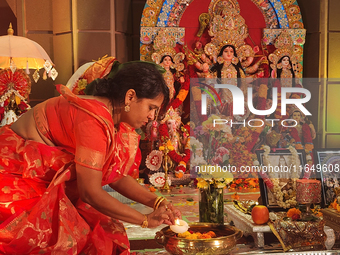 A Bengali Hindu woman performs prayers during the Durga Puja festival at a pandal (temporary temple) in Mississauga, Ontario, Canada, on Oct...