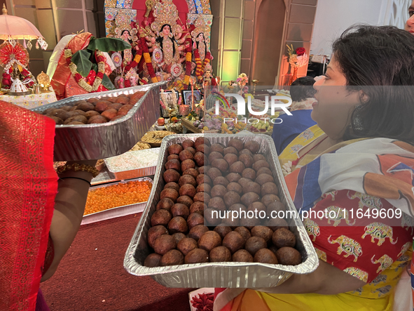 Bengali Hindu women carry trays of offerings during the Durga Puja festival at a pandal (temporary temple) in Mississauga, Ontario, Canada,...