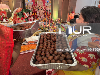 Bengali Hindu women carry trays of offerings during the Durga Puja festival at a pandal (temporary temple) in Mississauga, Ontario, Canada,...