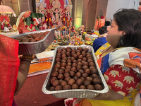 Bengali Hindu women carry trays of offerings during the Durga Puja festival at a pandal (temporary temple) in Mississauga, Ontario, Canada,...