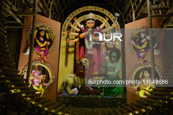 An idol of the Hindu goddess 'Durga' is pictured as devotees arrive to see it during the Durga Puja festival in Siliguri, India, on October...