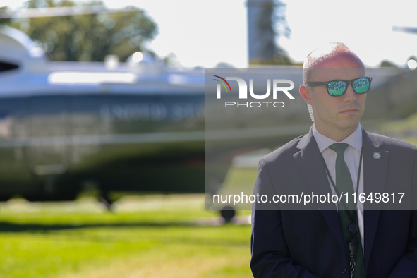 A U.S. Secret Service officer stands guard on the South Lawn of the White House on October 8, 2024 as Marine One prepares to take off with P...