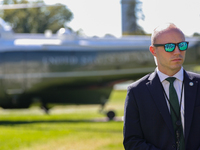 A U.S. Secret Service officer stands guard on the South Lawn of the White House on October 8, 2024 as Marine One prepares to take off with P...