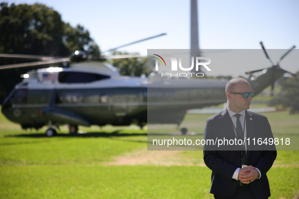 A U.S. Secret Service officer stands guard on the South Lawn of the White House on October 8, 2024 as Marine One prepares to take off with P...