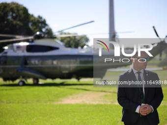 A U.S. Secret Service officer stands guard on the South Lawn of the White House on October 8, 2024 as Marine One prepares to take off with P...