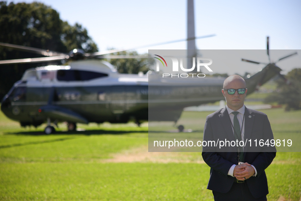 A U.S. Secret Service officer stands guard on the South Lawn of the White House on October 8, 2024 as Marine One prepares to take off with P...