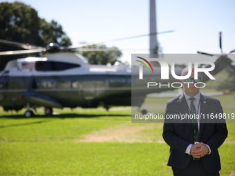 A U.S. Secret Service officer stands guard on the South Lawn of the White House on October 8, 2024 as Marine One prepares to take off with P...