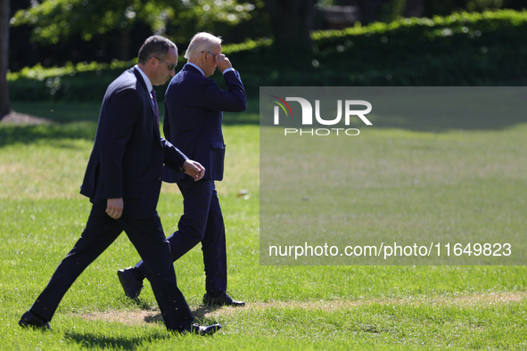 A U.S. Secret Service agent walks alongside President Joe Biden as he departs the White House to board Marine One en route to Milwaukee, Wis...