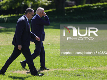 A U.S. Secret Service agent walks alongside President Joe Biden as he departs the White House to board Marine One en route to Milwaukee, Wis...