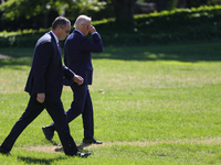 A U.S. Secret Service agent walks alongside President Joe Biden as he departs the White House to board Marine One en route to Milwaukee, Wis...