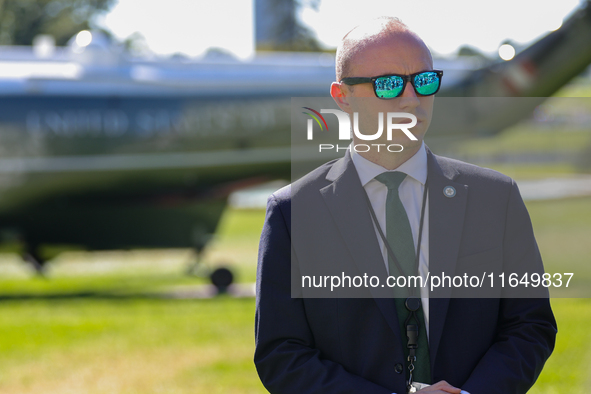 A U.S. Secret Service officer stands guard on the South Lawn of the White House on October 8, 2024 as Marine One prepares to take off with P...