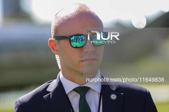 Members of the press are reflected in the sunglasses of a A U.S. Secret Service officer standing guard on the South Lawn of the White House...