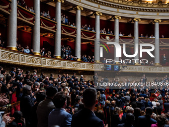 At the National Assembly in Paris, France, on October 8, 2024, applause and deputies stand in honor of the families of two Franco-Israeli ho...