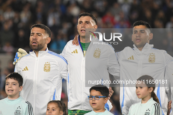 Nicolas Otamendi, Emiliano Martinez, and Cristian Romero stand during the national anthems ceremony before a match between Argentina and Chi...