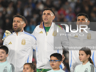 Nicolas Otamendi, Emiliano Martinez, and Cristian Romero stand during the national anthems ceremony before a match between Argentina and Chi...