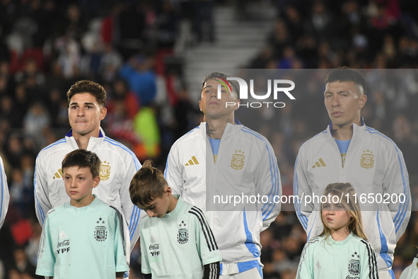 Julian Alvarez, Enzo Fernandez, and Lisandro Martinez of Argentina stand during the national anthems ceremony before a match between Argenti...