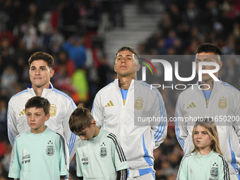 Julian Alvarez, Enzo Fernandez, and Lisandro Martinez of Argentina stand during the national anthems ceremony before a match between Argenti...