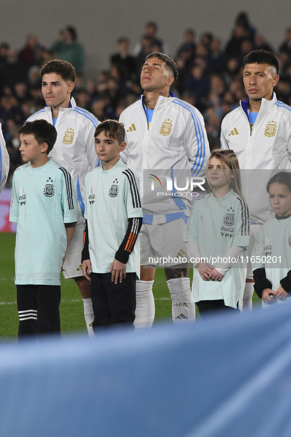 Julian Alvarez, Enzo Fernandez, and Lisandro Martinez of Argentina stand during the national anthems ceremony before a match between Argenti...