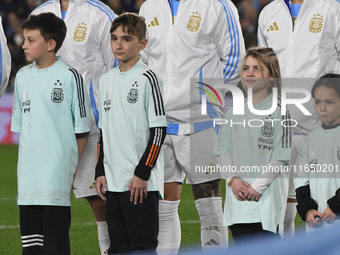 Julian Alvarez, Enzo Fernandez, and Lisandro Martinez of Argentina stand during the national anthems ceremony before a match between Argenti...