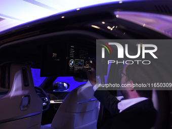 A man controls a touch screen panel of a BMW i7 electric car during a press conference of a joint venture between Tata Technologies and BMW...