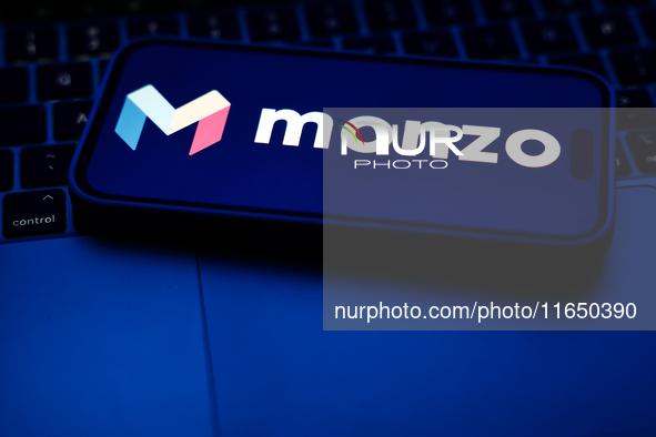 A laptop keyboard and Monzo logo displayed on a phone screen are seen in this illustration photo taken in Poland on October 8, 2024. 