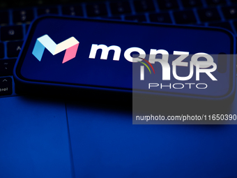 A laptop keyboard and Monzo logo displayed on a phone screen are seen in this illustration photo taken in Poland on October 8, 2024. (