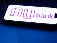 A laptop keyboard and Nubank logo displayed on a phone screen are seen in this illustration photo taken in Poland on October 8, 2024. (