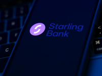 A laptop keyboard and Starling Bank logo displayed on a phone screen are seen in this illustration photo taken in Poland on October 8, 2024....