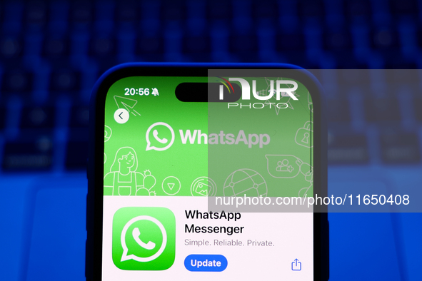 A laptop keyboard and WhatsApp on App Store displayed on a phone screen are seen in this illustration photo taken in Poland on October 8, 20...