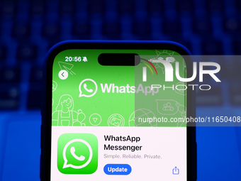 A laptop keyboard and WhatsApp on App Store displayed on a phone screen are seen in this illustration photo taken in Poland on October 8, 20...