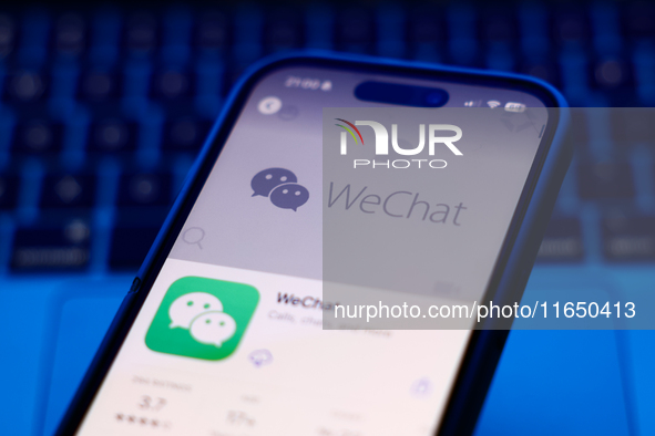 A laptop keyboard and WeChat on App Store displayed on a phone screen are seen in this illustration photo taken in Poland on October 8, 2024...