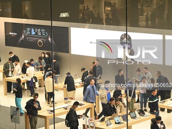 Customers experience Apple products at the Taikoo Li Apple Store in Chengdu, China, on October 8, 2024. (