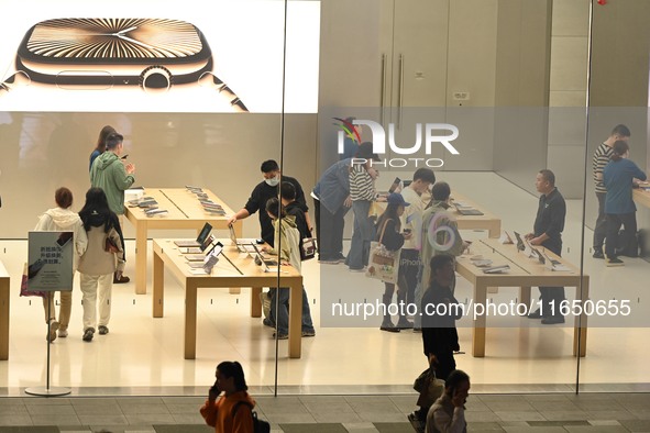 Customers experience Apple products at the Taikoo Li Apple Store in Chengdu, China, on October 8, 2024. 