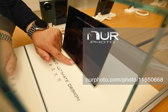 A Huawei Mate XT triple foldable screen mobile phone is displayed at a Huawei store located at IFS International Financial Center on Chunxi...