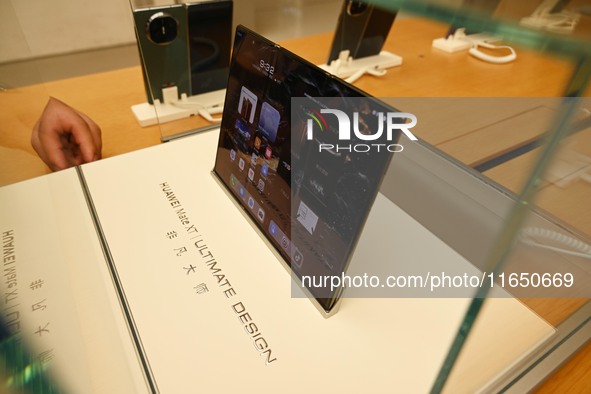 A Huawei Mate XT triple foldable screen mobile phone is displayed at a Huawei store located at IFS International Financial Center on Chunxi...