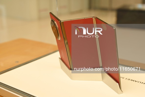 A Huawei Mate XT triple foldable screen mobile phone is displayed at a Huawei store located at IFS International Financial Center on Chunxi...