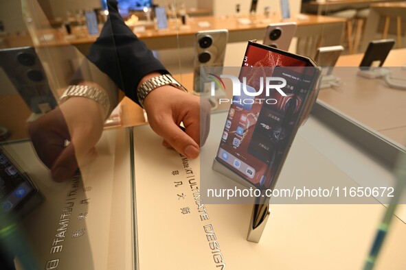 A Huawei Mate XT triple foldable screen mobile phone is displayed at a Huawei store located at IFS International Financial Center on Chunxi...