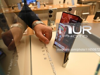 A Huawei Mate XT triple foldable screen mobile phone is displayed at a Huawei store located at IFS International Financial Center on Chunxi...