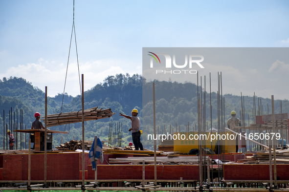 Workers work at the construction site of the 2024 help workshop in Congjiang County, Guizhou Province, China, on October 8, 2024. 